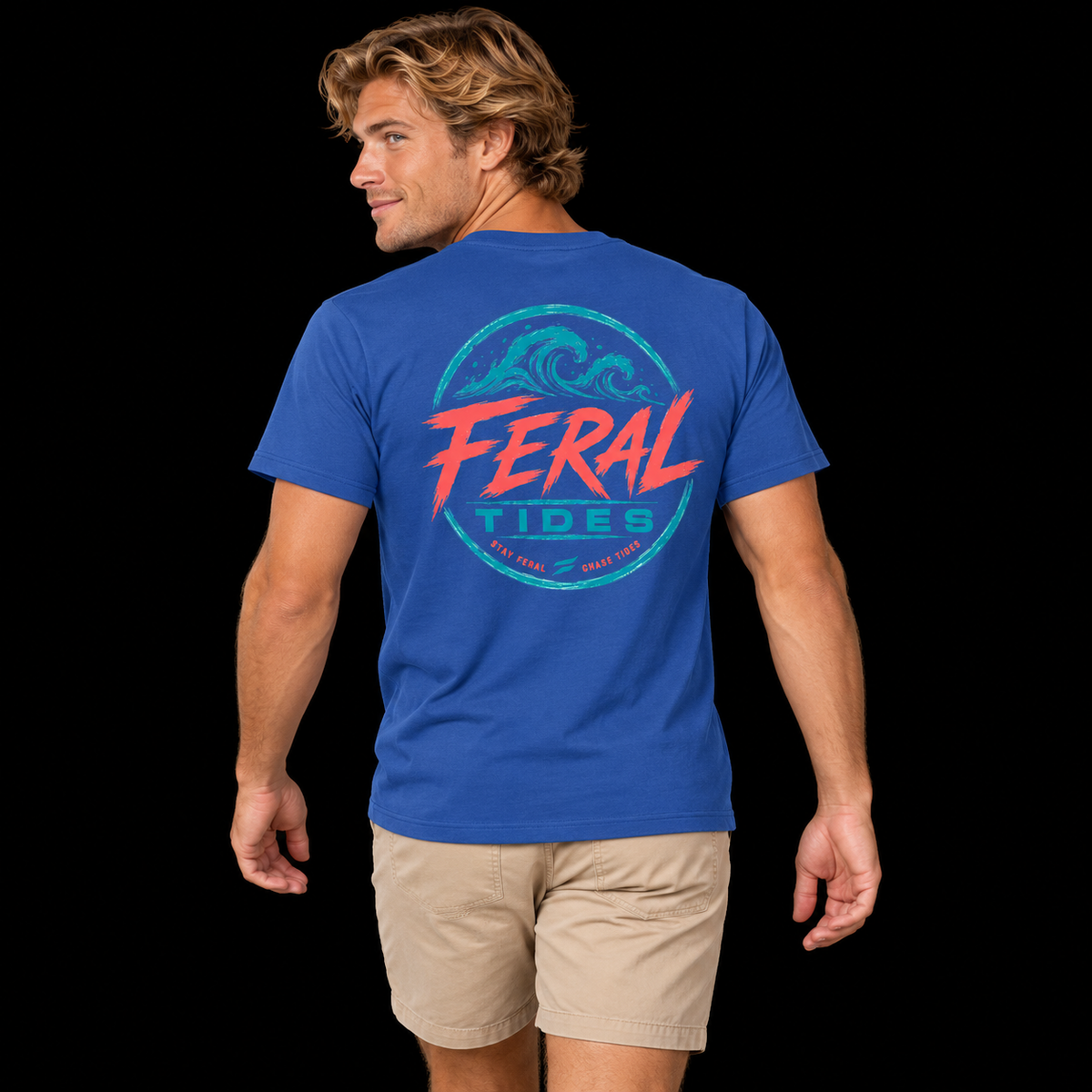 Male model wearing the Royal Feral Tides Tidal Rebel Tee, looking back over left shoulder with arms relaxed, showing the large coral-and-teal wave graphic on the back against a solid black background.