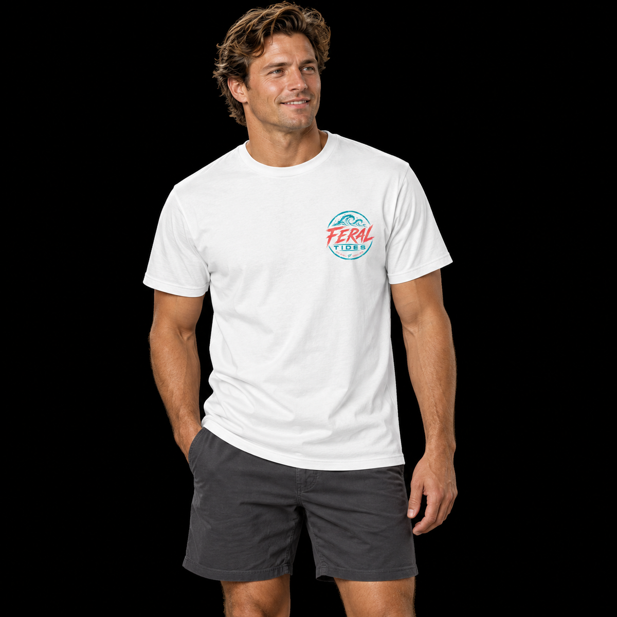 Male model wearing the White Feral Tides Tidal Rebel Tee, standing casually with one hand in pocket, showing the small coral-and-teal wave logo on the front chest against a solid black background.